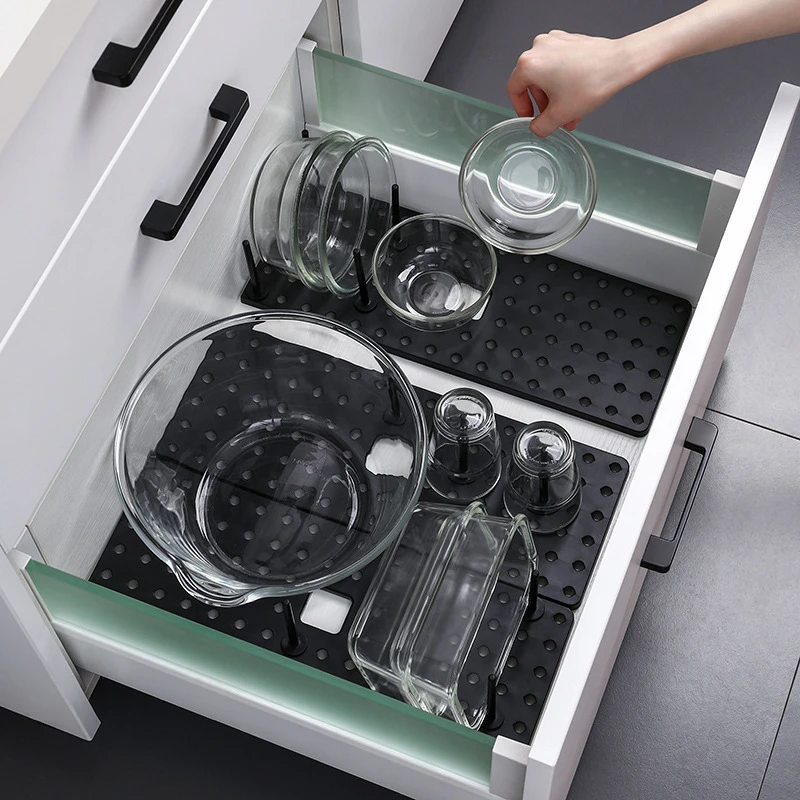Organisateur de tiroir télescopique installé sur un évier de cuisine moderne.