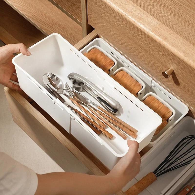Organisateur sous forme de rangement tiroir extensible cuisine en plastique blanc.