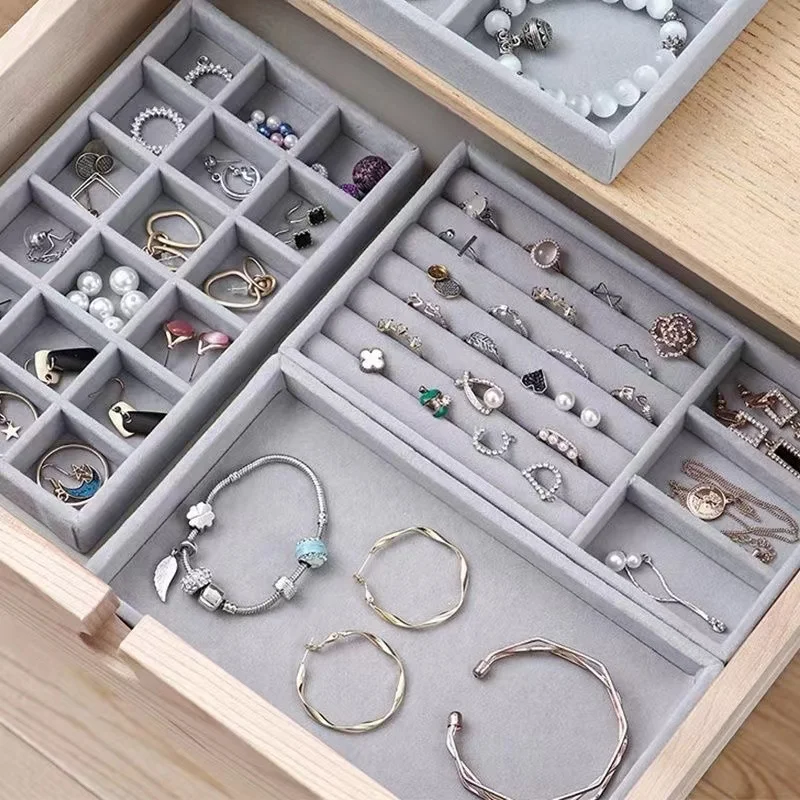 Plateau organisateur de bijoux en velours gris avec compartiments modulaires.